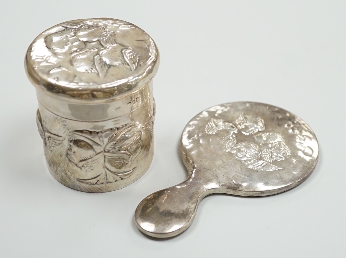 An Edwardian repousse silver Reynolds Angels toilet jar and cover, by William Comyns, London, 1901 and a later similar hand mirror by William Neale Ltd.